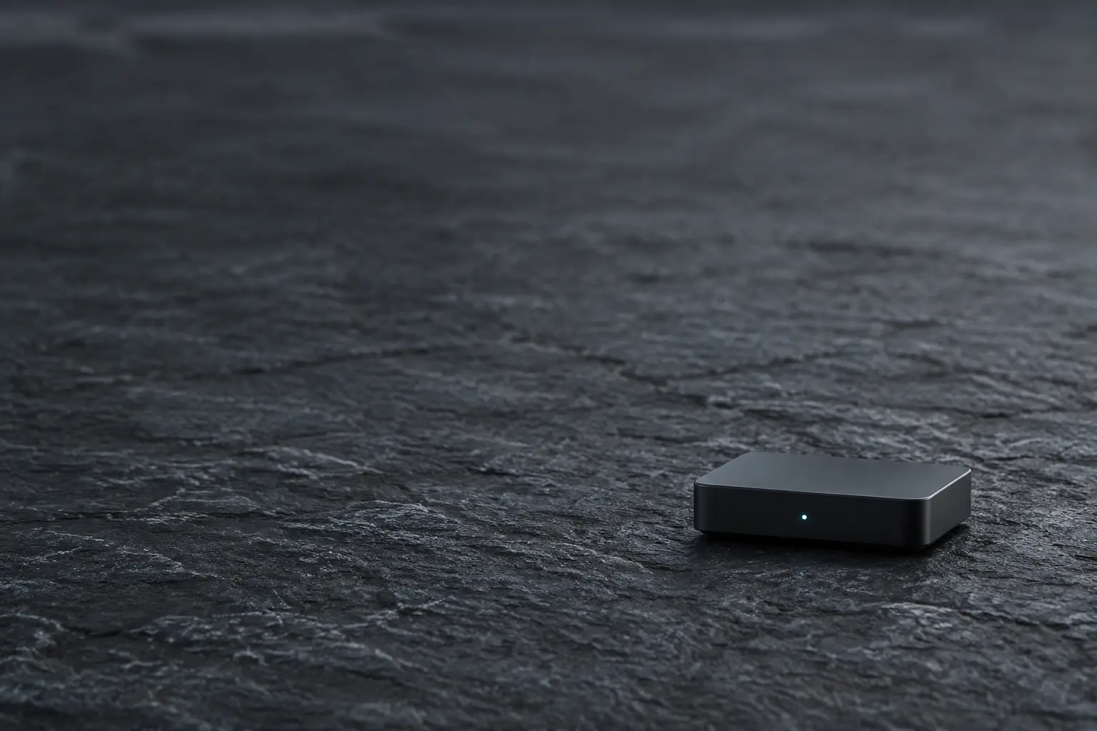 A minimal graphite control node with a single teal status light